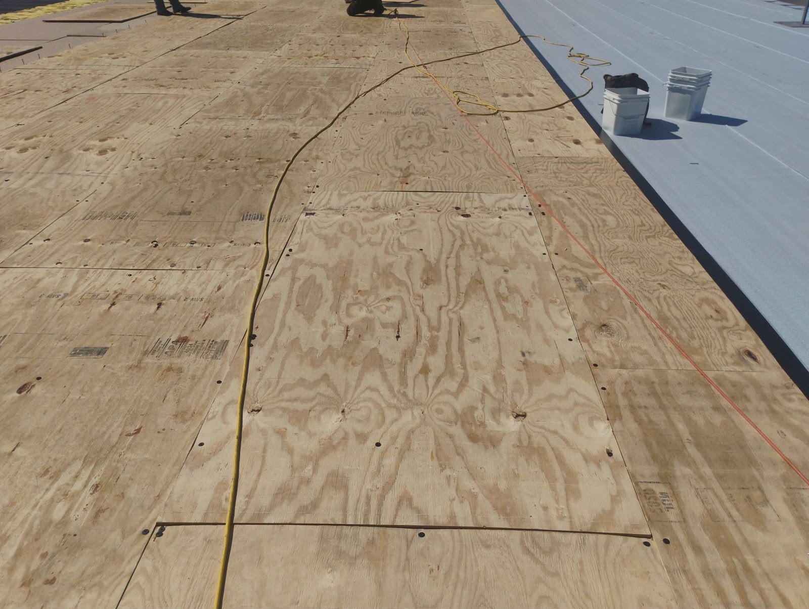 Single-ply roofing membrane laid over cover board on a flat roof